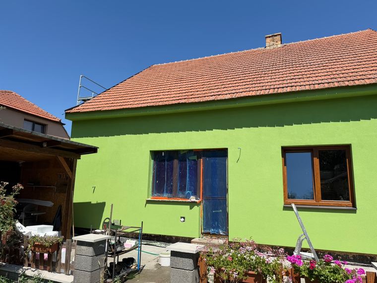 Dokončená zelená fasáda rodinného domu po zateplení a aplikaci dekorativní omítky