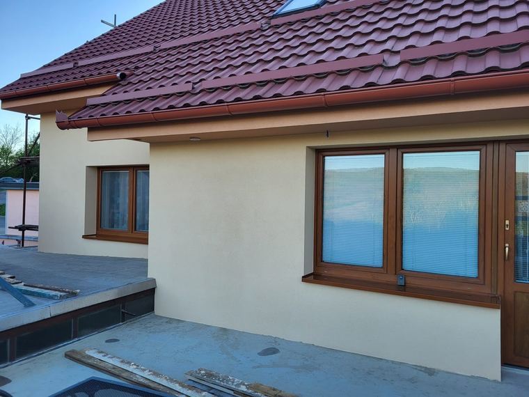 Rodinný dům s novou fasádou, červenou střechou a klempířskými prvky